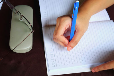 Midsection of person reading book on table