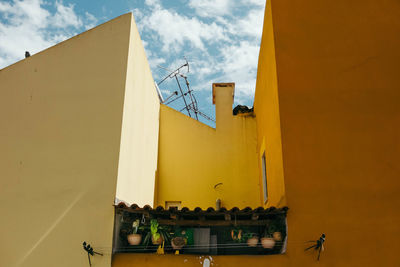 Low angle view of yellow building against sky