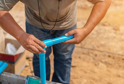 Workers wear pipes that are glued together in plumbing of building.