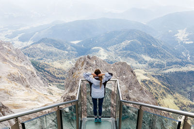 Millennial girl enjoys the views of alps from the observation deck