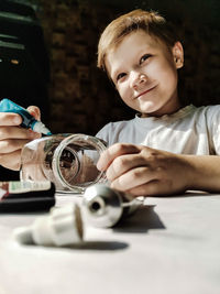 Portrait of boy holding table