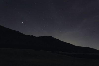 Silhouette mountain against sky at night