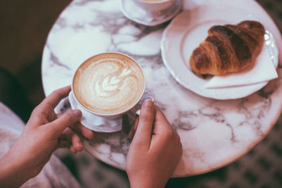 Cropped image of hand holding coffee cup