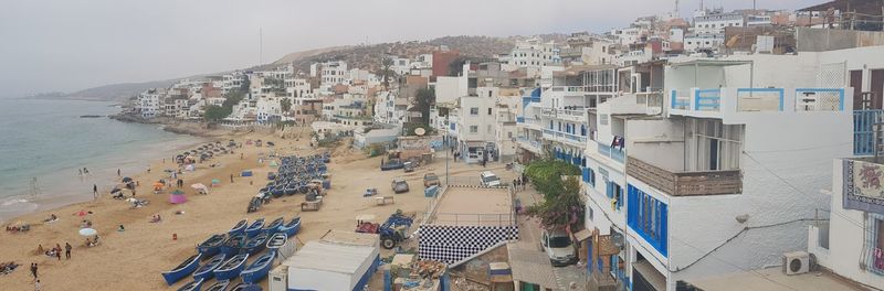 High angle view of buildings by sea against sky