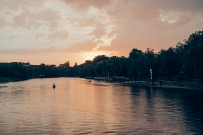 Scenic view of river against sky at sunset