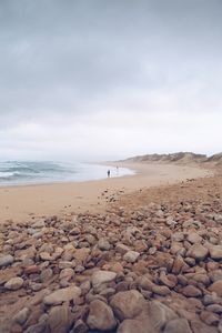 Pebbles on beach against sky