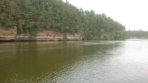 Scenic view of river by trees against sky