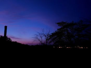 Silhouette trees against sky at night