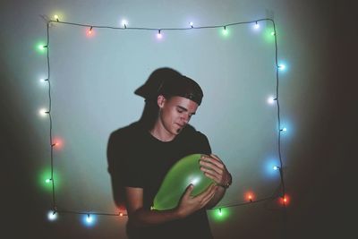 Rear view of woman standing on illuminated street at night