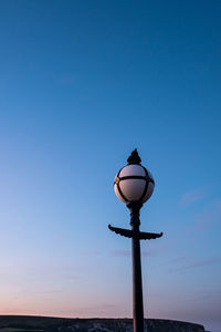 A old victorian lamp on the old pier, swanage at sunset.
