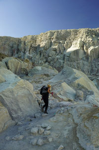 Low angle view of woman climbing on mountain