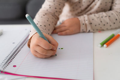 Portrait of cute preschooler child girl drawing with pencils at home while sitting