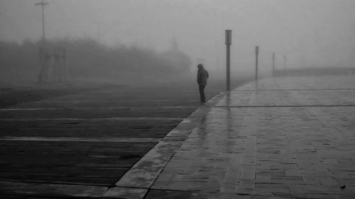 Rear view of person walking on footpath