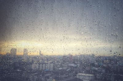 City seen through wet glass window during rainy season