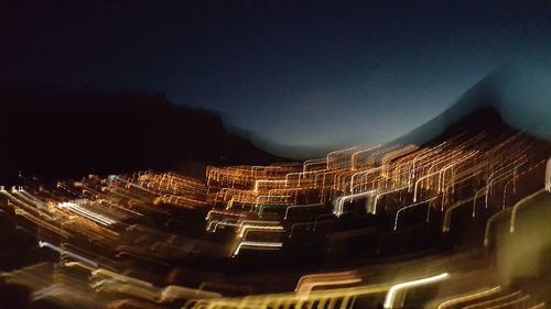 Illuminated city against clear sky at night