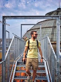 Portrait of a young man standing on railing