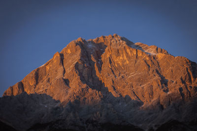 Low angle view of rocky mountains against clear sky