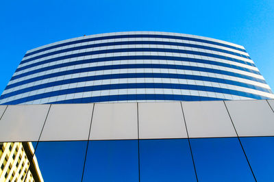 Low angle view of modern building against clear blue sky