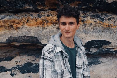 Portrait of smiling man standing against wall