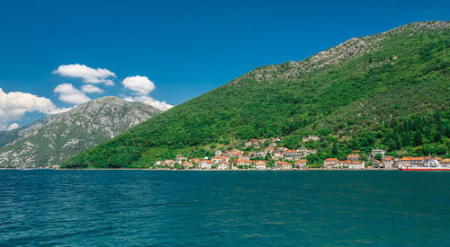 Scenic view of sea and mountains against blue sky