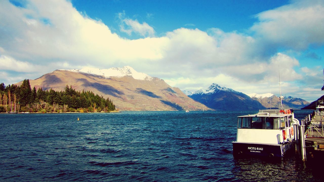 mountain, water, waterfront, sky, mountain range, tranquil scene, scenics, cloud - sky, tranquility, beauty in nature, nautical vessel, lake, cloud, nature, rippled, boat, cloudy, transportation, idyllic, day