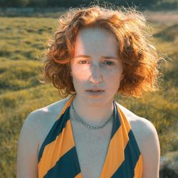 Portrait of beautiful young woman standing on land