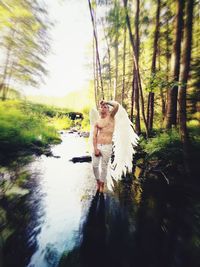 Full length of woman standing in forest