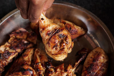 Close-up of person preparing food on barbecue grill