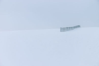 Snow on landscape against clear sky