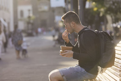 Midsection of man holding ice cream on street