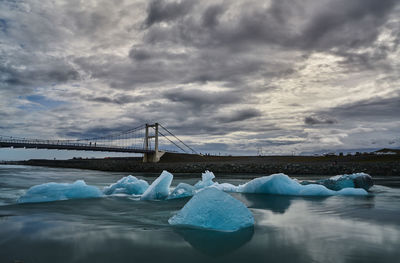 Bridge over sea against sky during winter