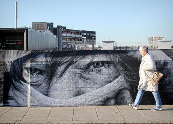 Full length of man standing on street against clear sky