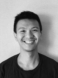 Portrait of smiling young man against white background