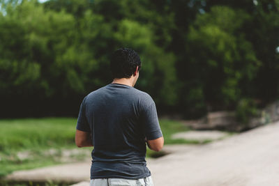 Rear view of man standing against trees