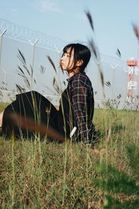 Young woman looking away on field