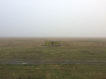 Information sign on field against clear sky