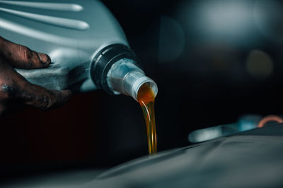 Close-up of hand pouring glass