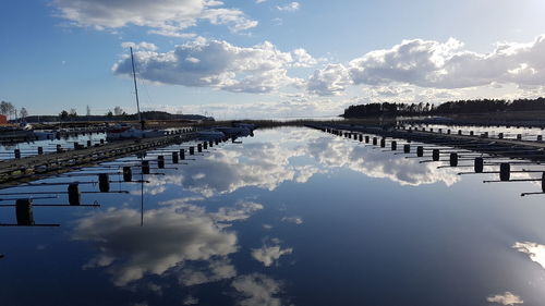 Panoramic view of swimming pool by lake against sky