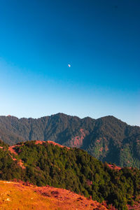 Scenic view of mountains against clear blue sky