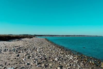 Scenic view of beach against clear blue sky