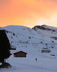 Scenic view of snow covered mountains against sky at sunset