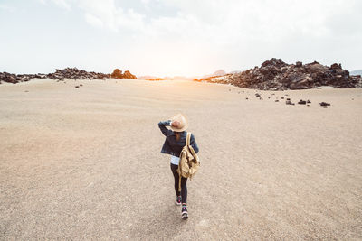 Man with woman walking on land against sky