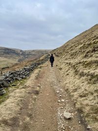 Rear view of man walking on mountain road