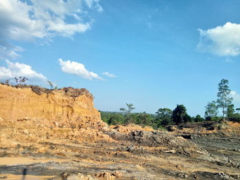 Rock formations on landscape against blue sky