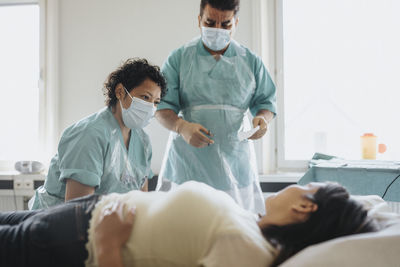 Male and female doctors examining patient in hospital