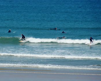 People surfboarding in sea