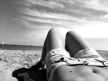 Low section of man lying on beach