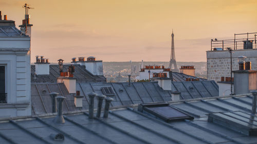Distant view of eiffel tower in city against sky during sunset