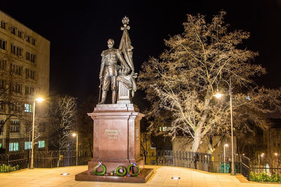 Statue of illuminated city at night