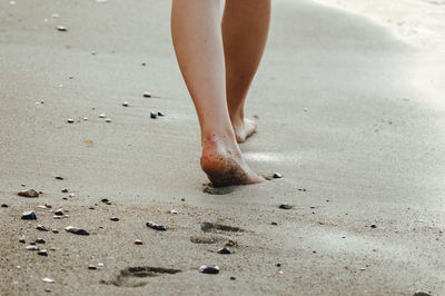 Low section of woman standing on beach